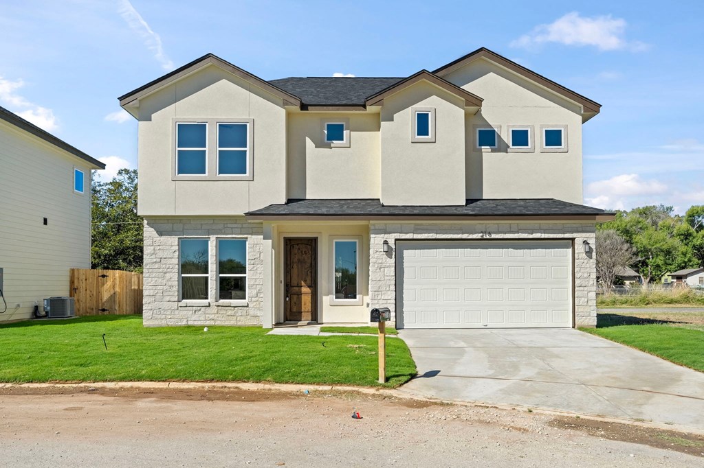 a beige house with a garage and a driveway