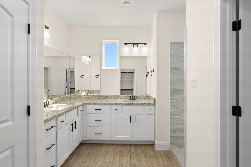 a bathroom with white cabinets and a sink and a mirror