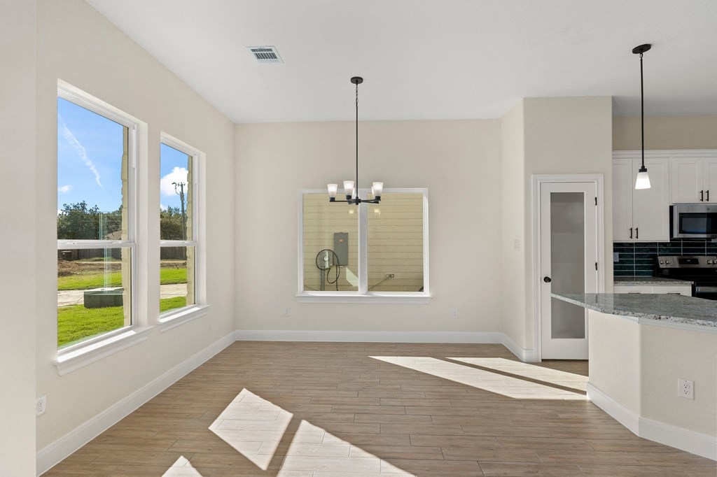 an empty room with a kitchen and a large window