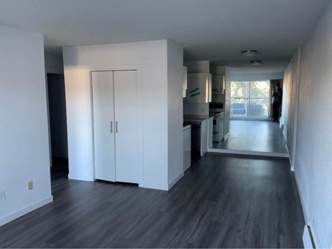 an empty living room with white walls and wood floors