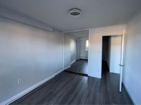 an empty living room with white walls and wood floors