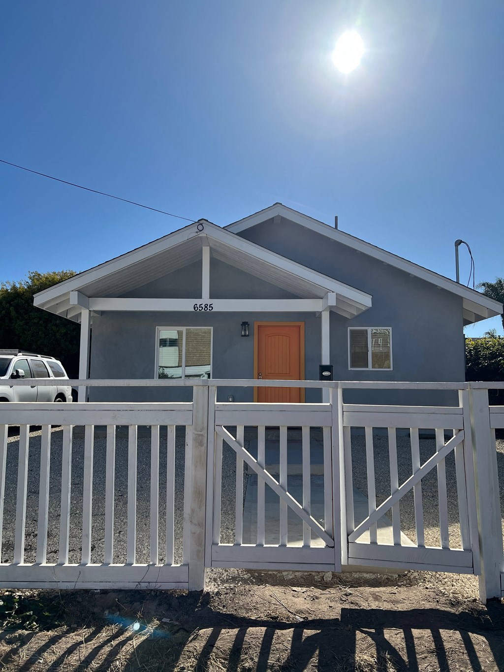 A house with a white fence and a brown door.
