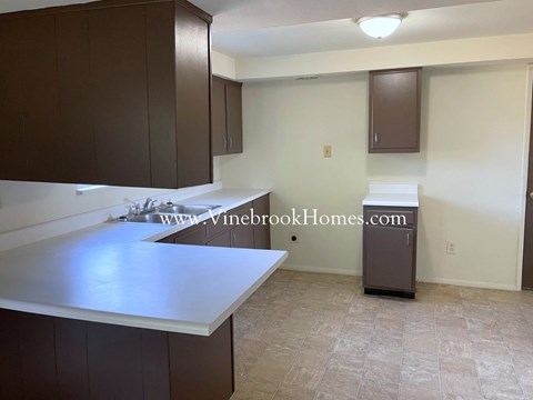 A kitchen with brown cabinets and a white countertop.