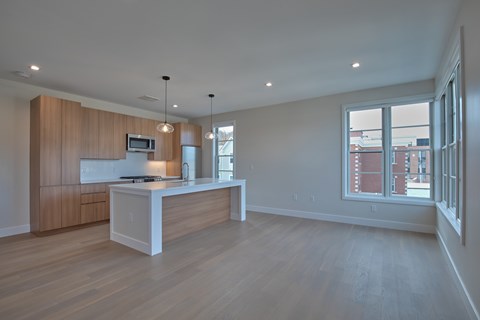 A kitchen with wooden cabinets and a white island.