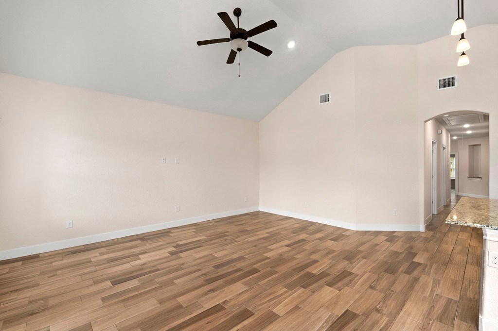 the living room with hardwood flooring and a ceiling fan