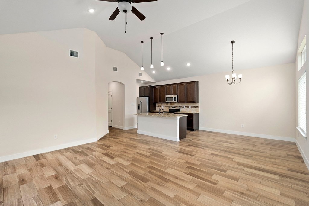 the living room and kitchen of a new home with wood flooring