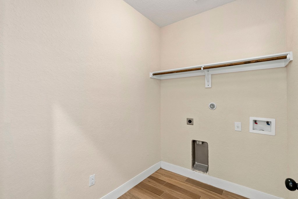the living room of a home with a white wall and a door to the hallway