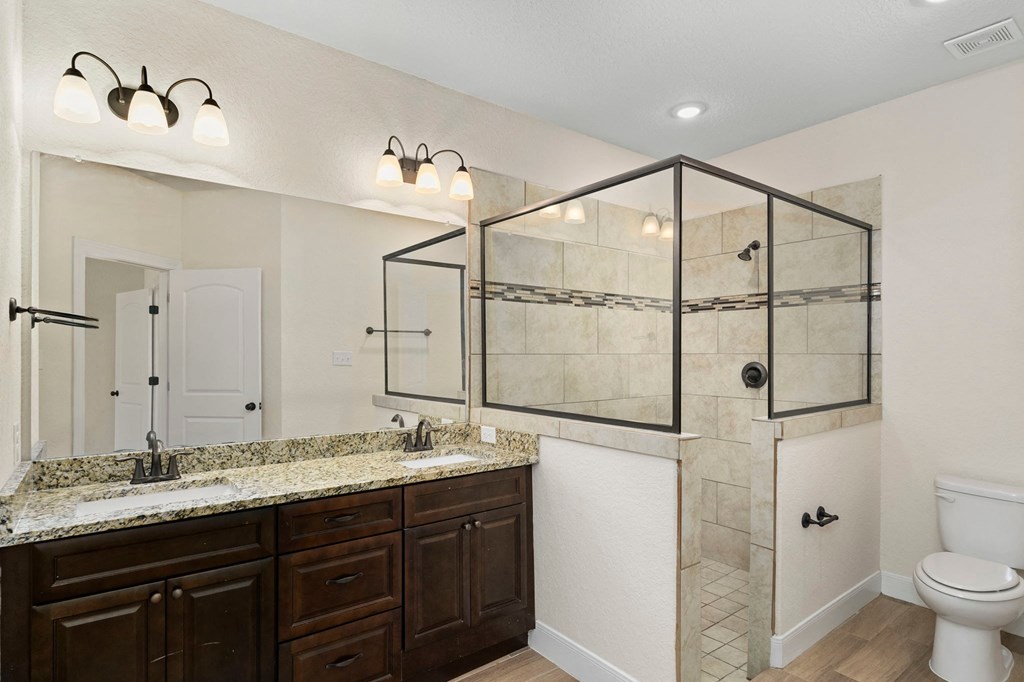a bathroom with a shower and a sink and a toilet
