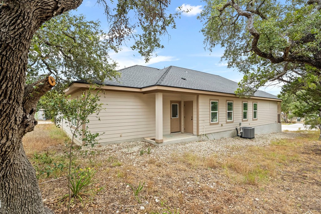 a small tan house with trees in front of it