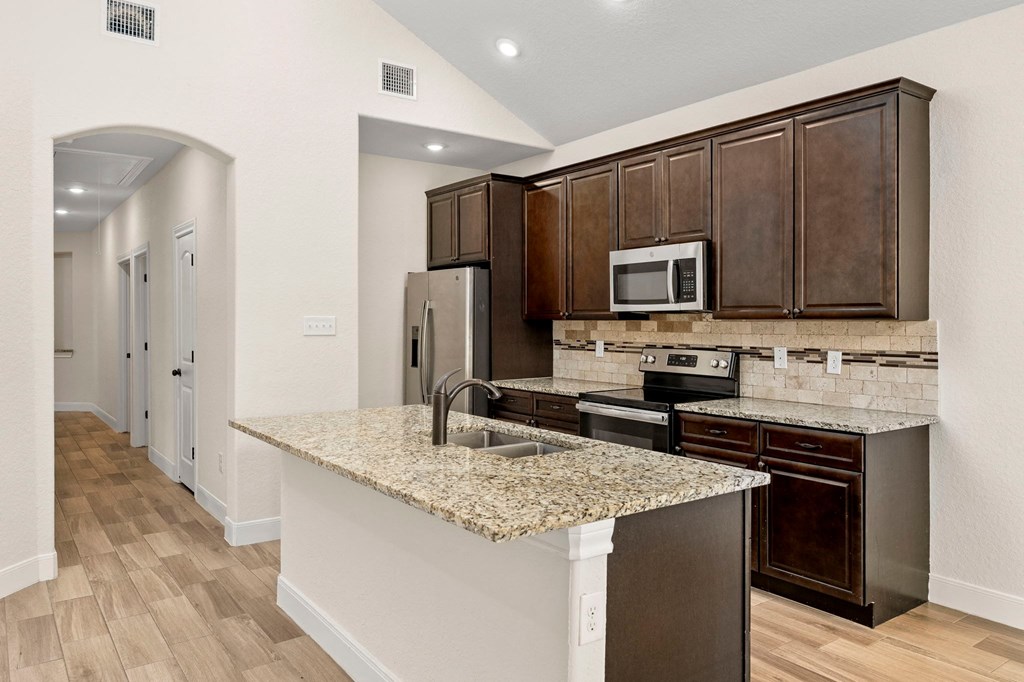 a kitchen with a granite counter top and stainless steel appliances