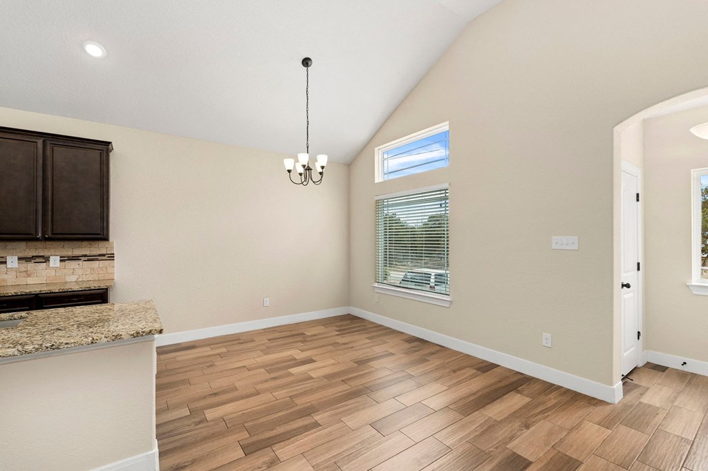 an empty living room with hardwood flooring and a window
