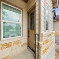 the front door of a house with two large windows