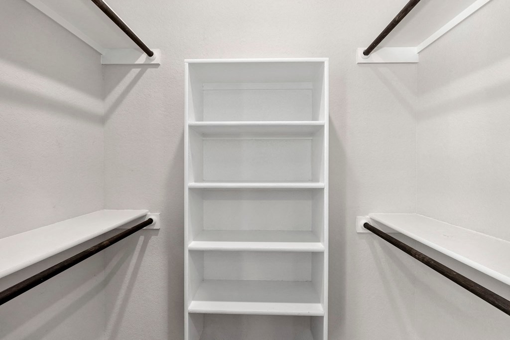 a white closet with white shelves and white walls
