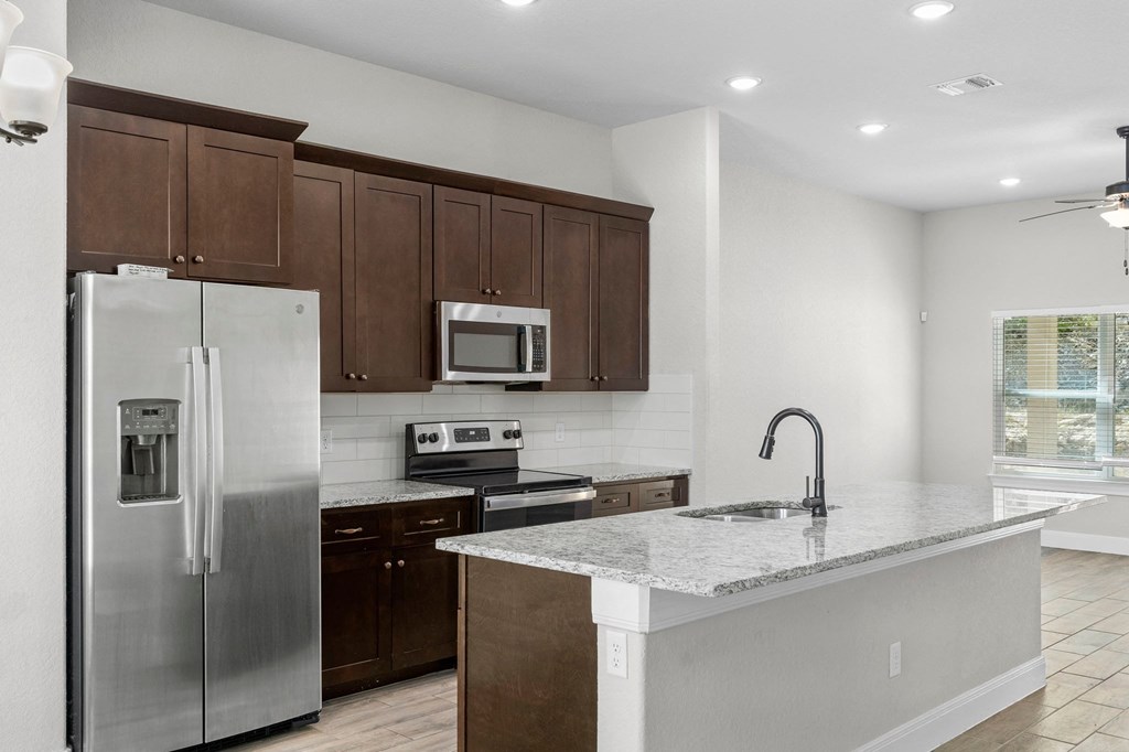 a kitchen with stainless steel appliances and a marble counter top