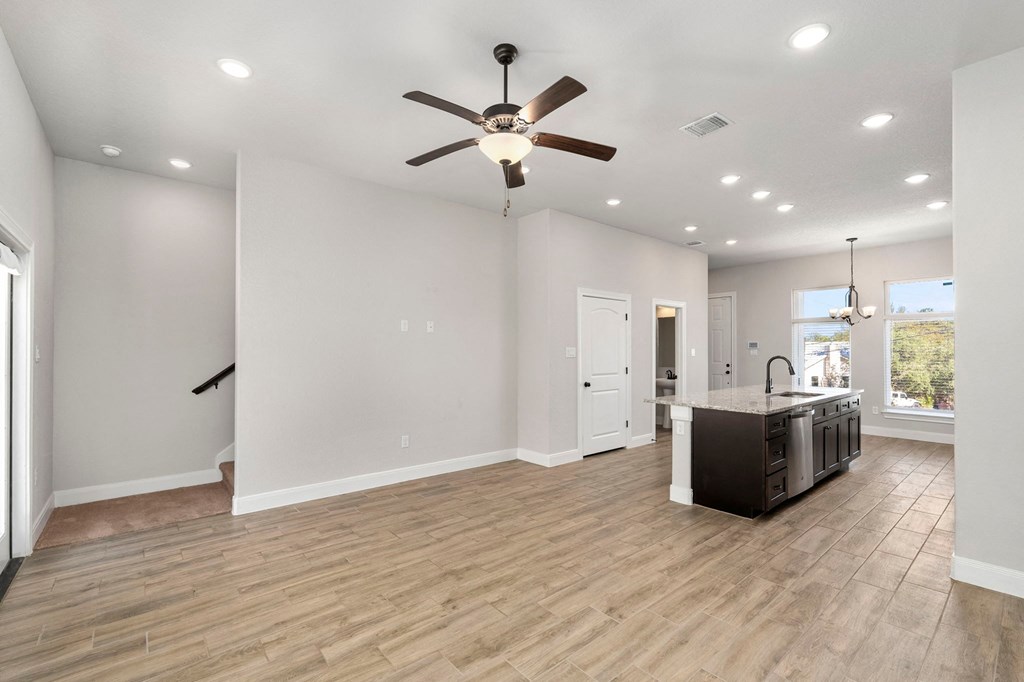 an open kitchen and living room with a ceiling fan