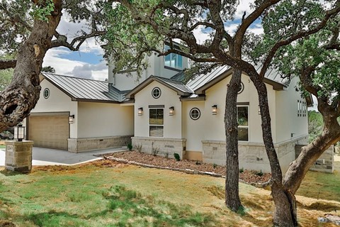 a white house with a yard and trees