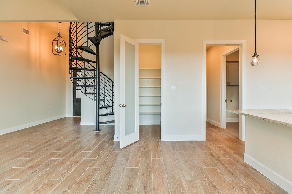 a living room with a staircase and a door to a closet