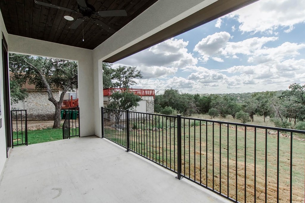 the view from the balcony of a home with a yard and a fence