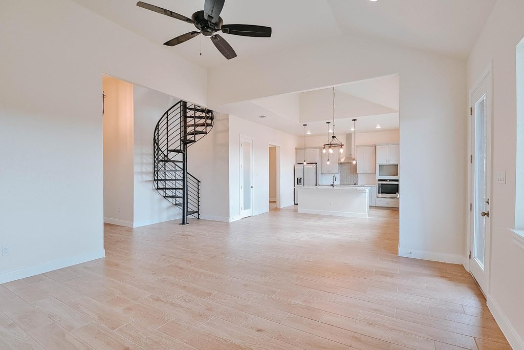 an empty living room with a spiral staircase in the middle