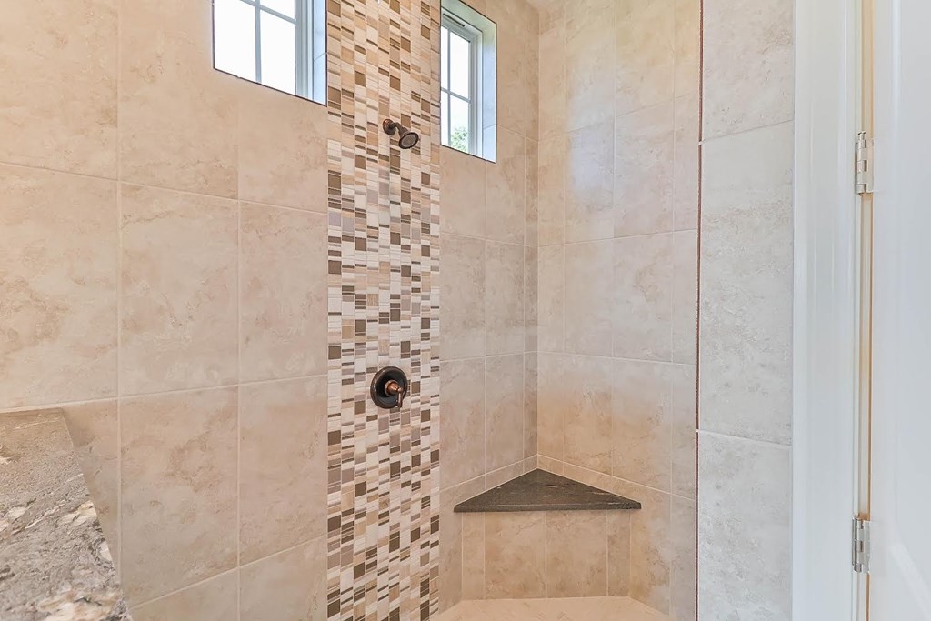a tiled shower in a bathroom with a window