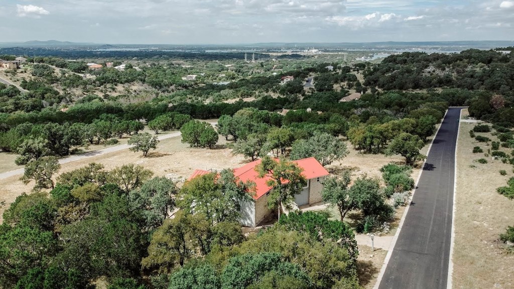 a house with a red roof and a road next to it
