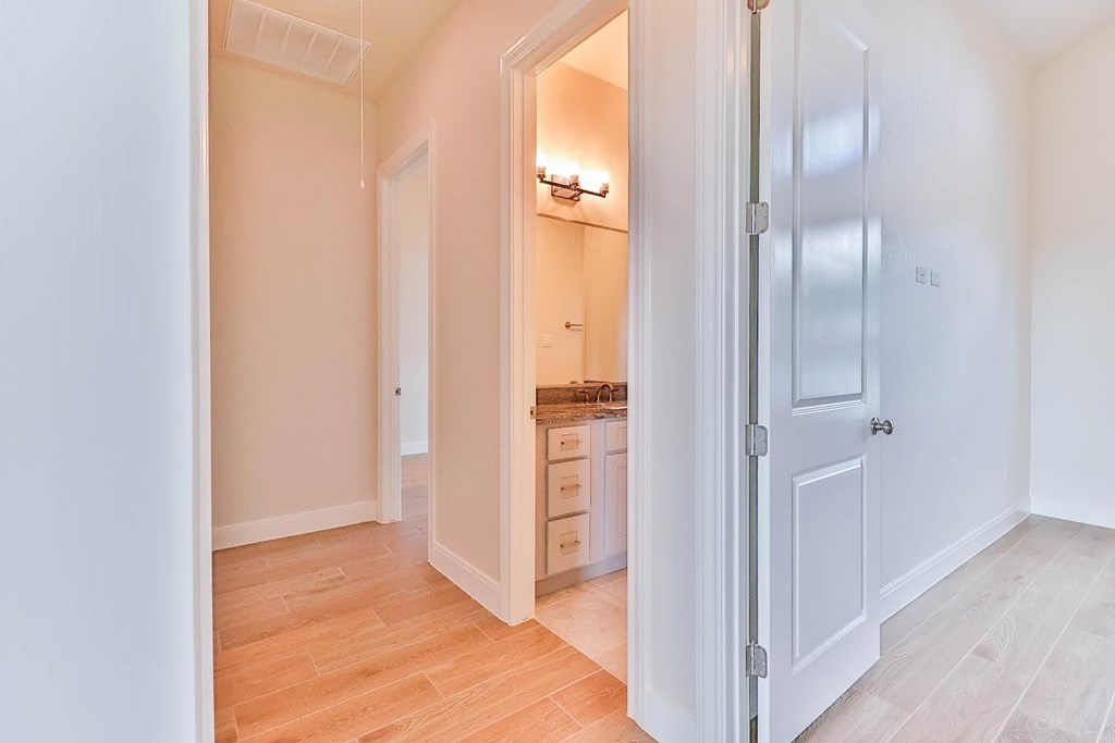 a bedroom with a closet and a bathroom with a mirror