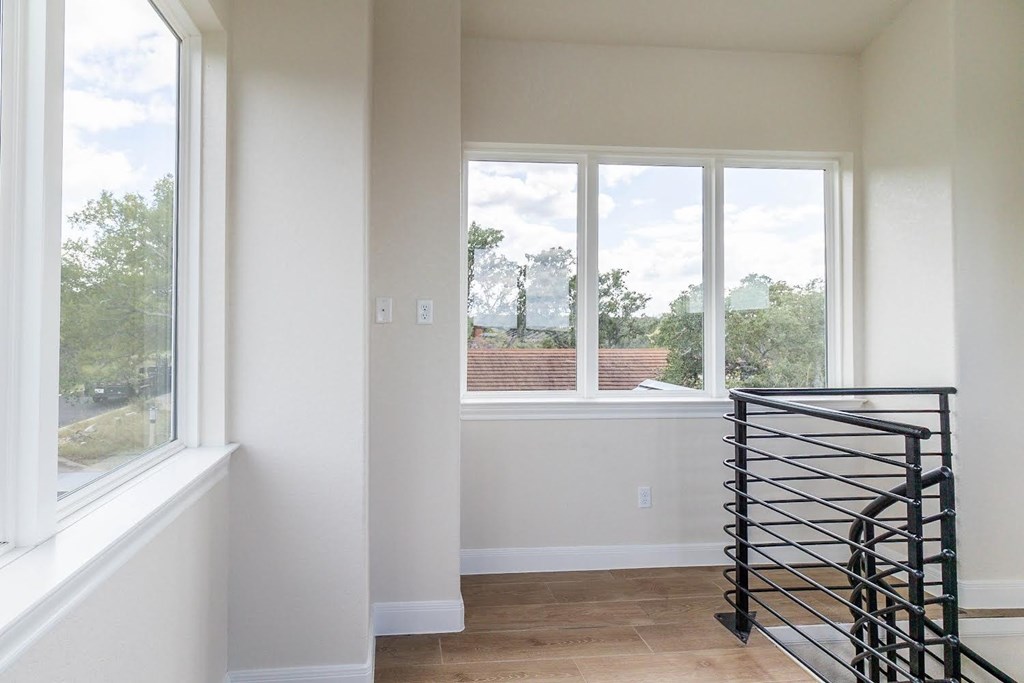 a view of a living room with large windows and a staircase