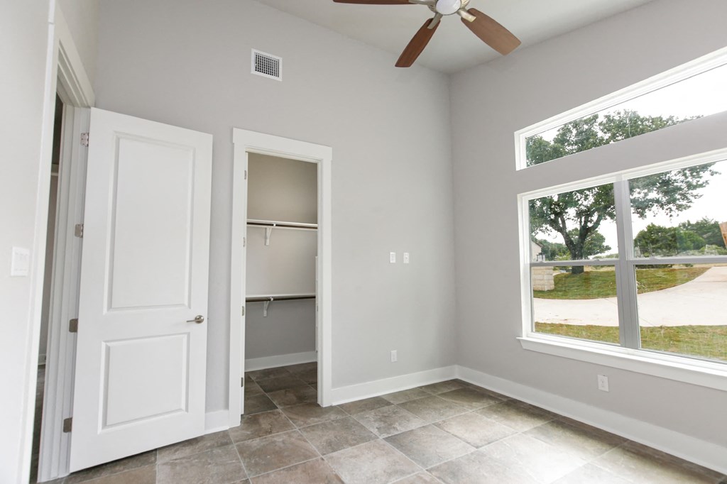 an empty room with a large window and a closet