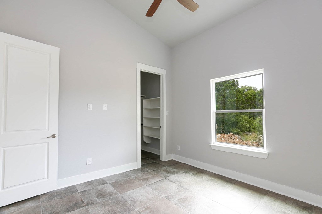 an empty room with a window and a closet