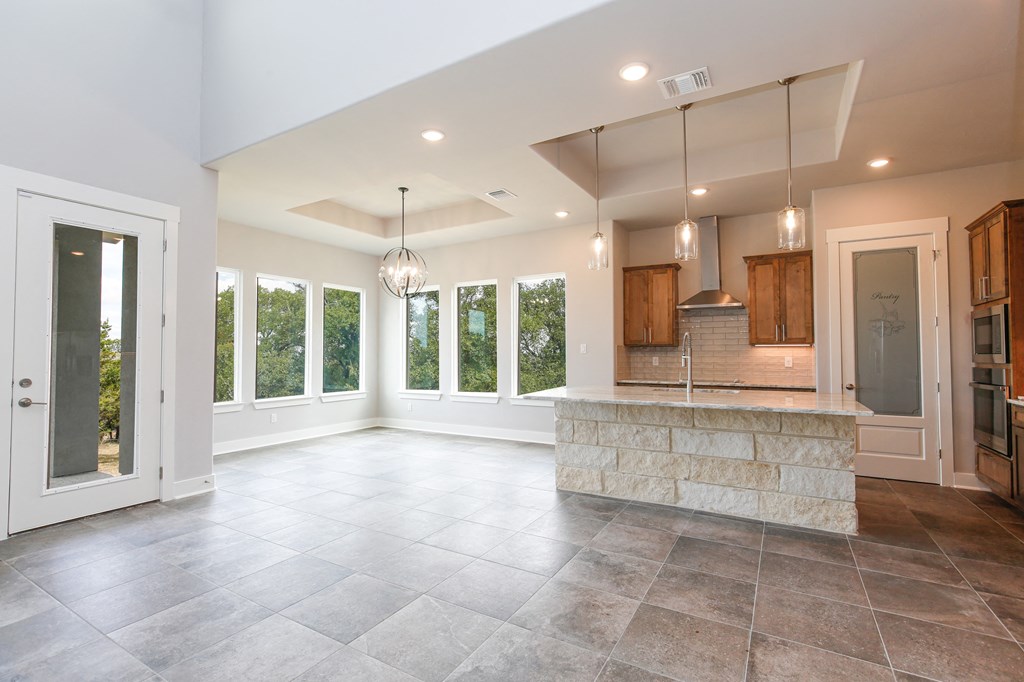a large living room with a kitchen and a door way