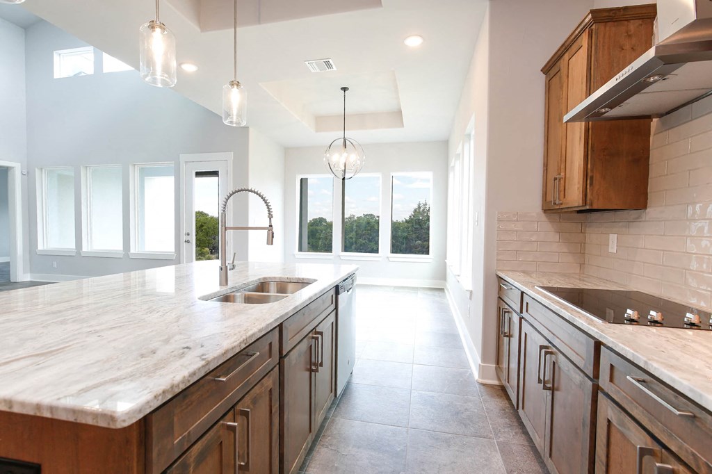 a large kitchen with wooden cabinets and a sink