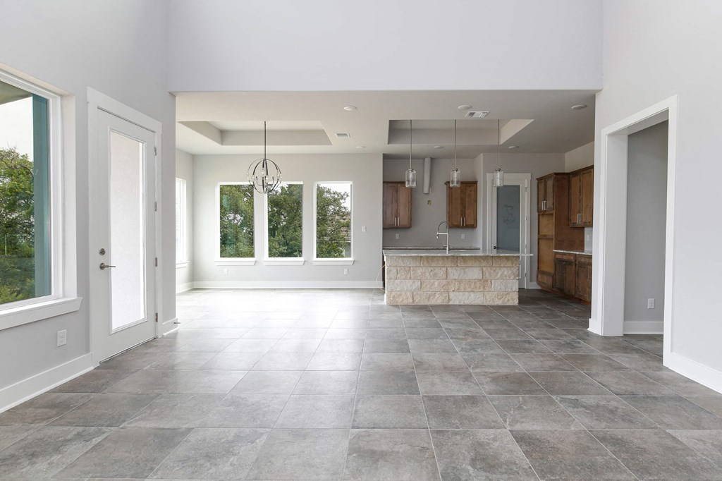 a large empty kitchen and living room with a large window