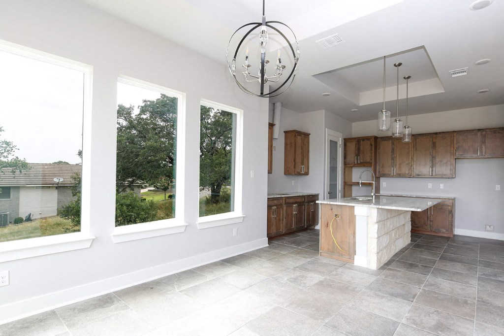 a kitchen with three windows and a marble counter top