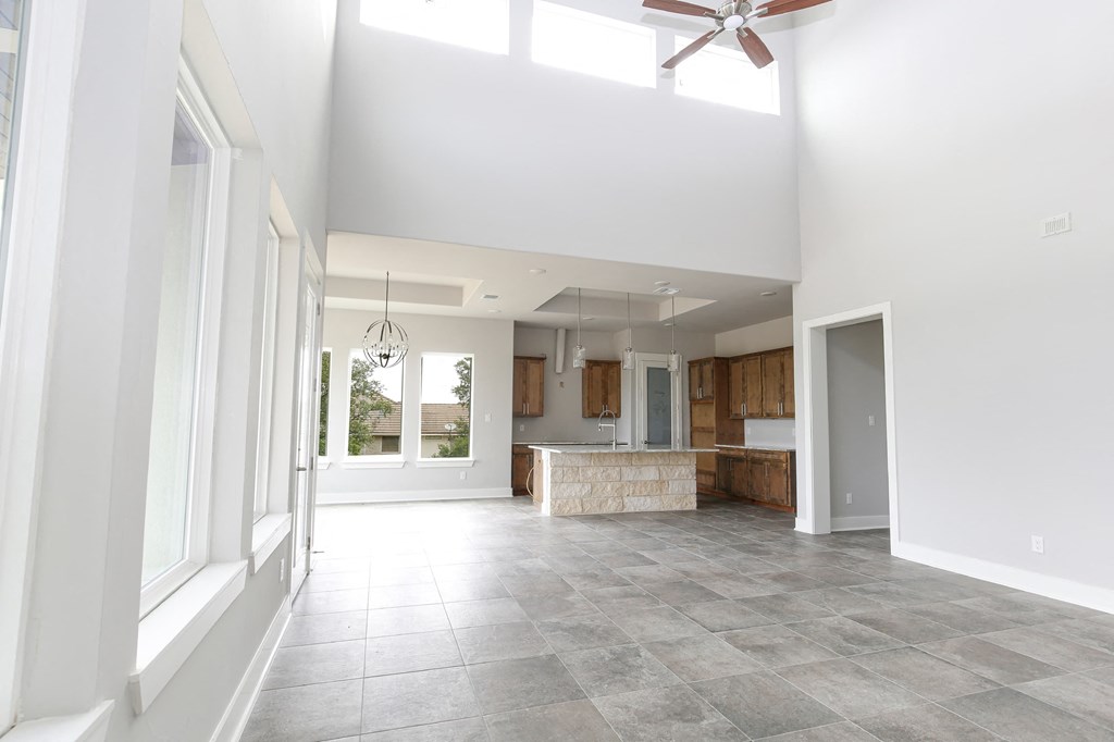 a large room with a kitchen and a ceiling fan