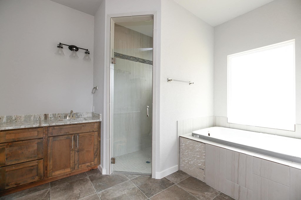 a bathroom with a tub and a shower and a sink