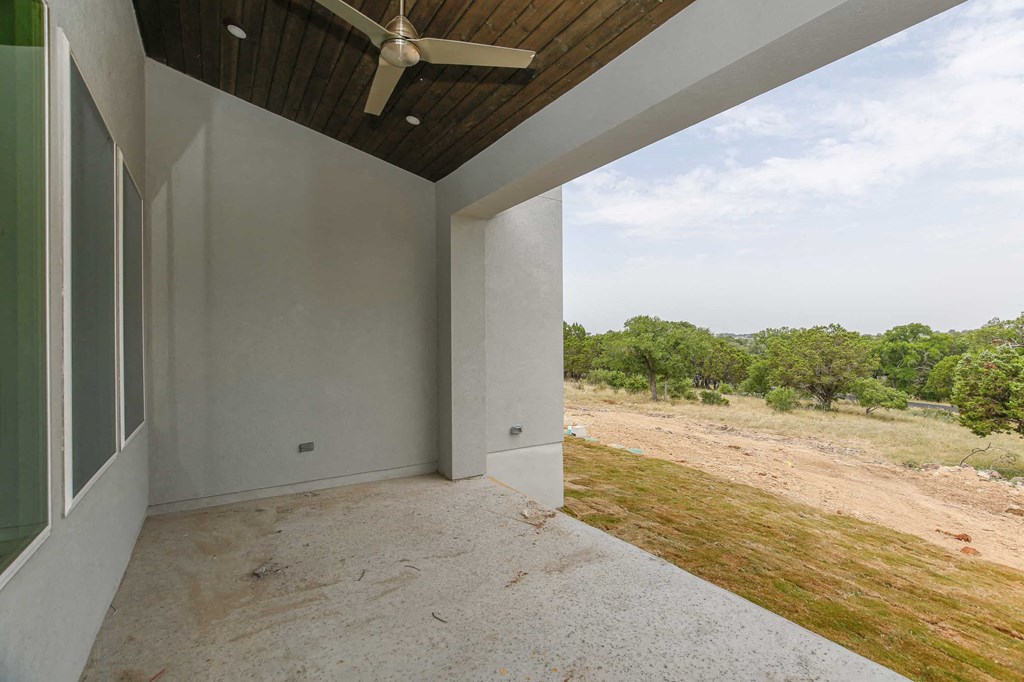 a large empty room with a ceiling fan and a view of a field