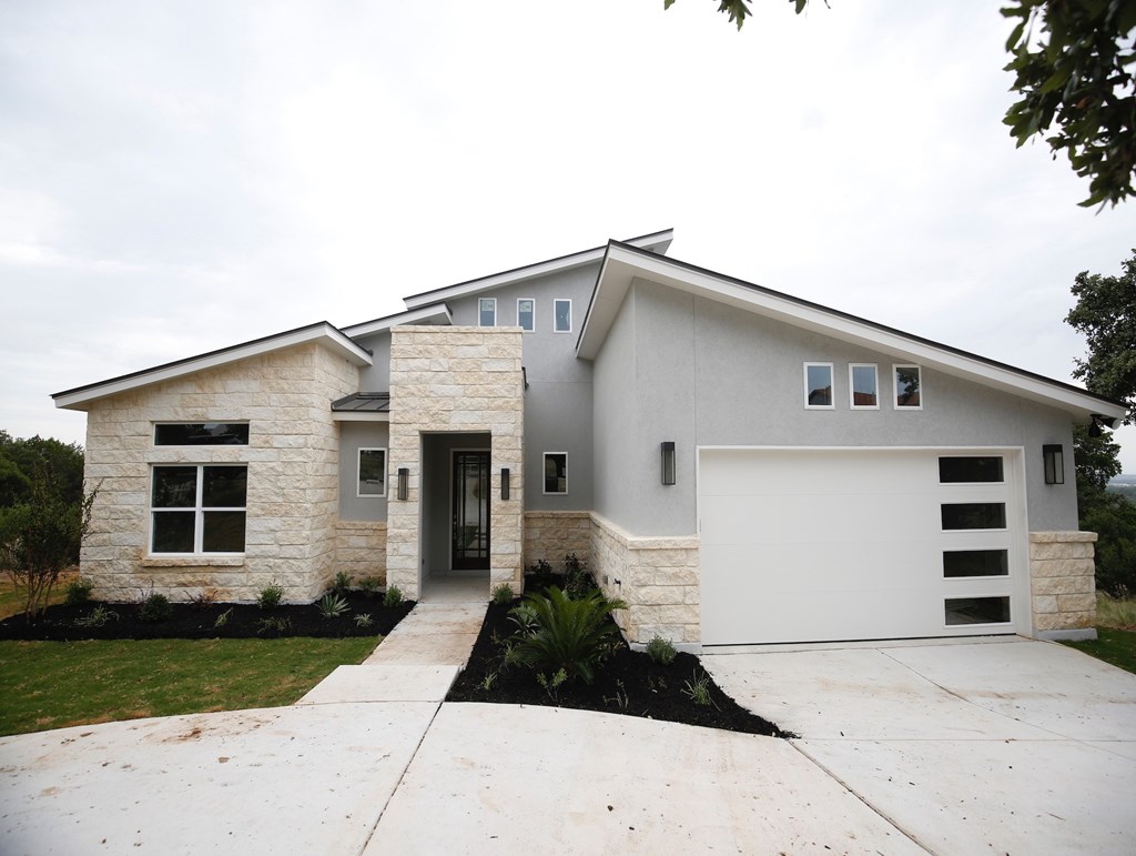 a white and gray house with a white garage door