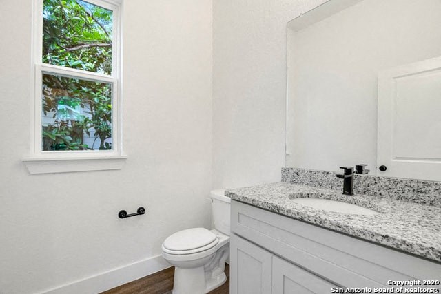 a bathroom with a toilet and a sink and a window
