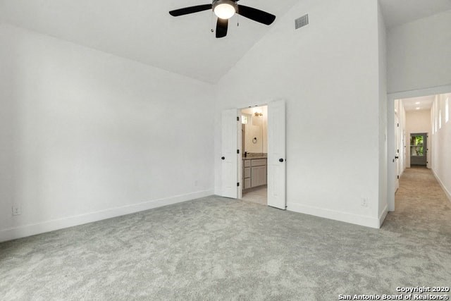 an empty living room with white walls and a ceiling fan