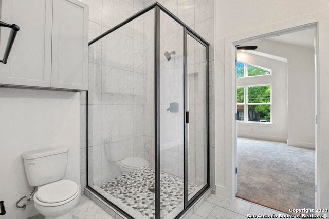 a white bathroom with a shower and a toilet