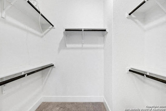 a white closet with empty shelves on the wall
