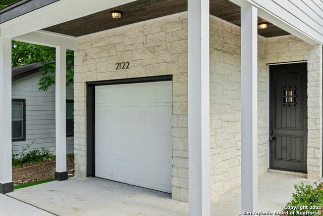 a garage door on the side of a brick house