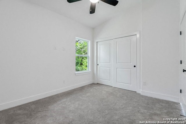 an empty room with a ceiling fan and a window