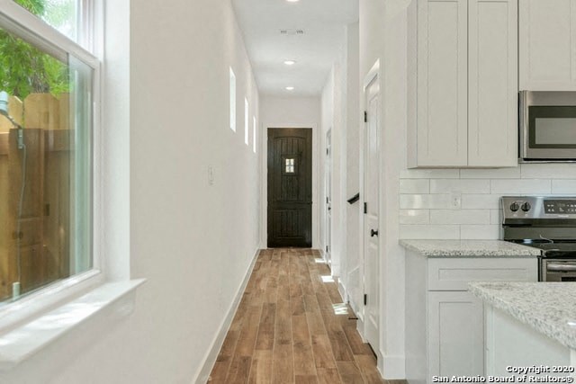 a white kitchen with a wooden floor and white cabinets