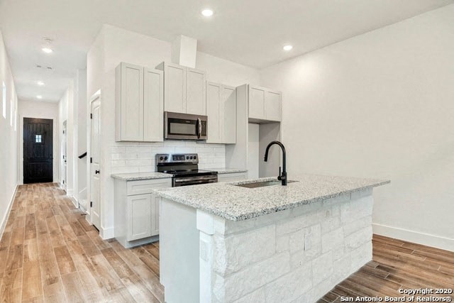 a white kitchen with a marble counter top