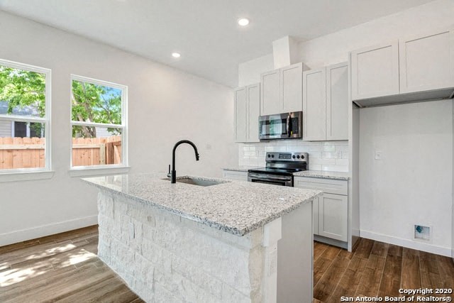 a white kitchen with a marble counter top