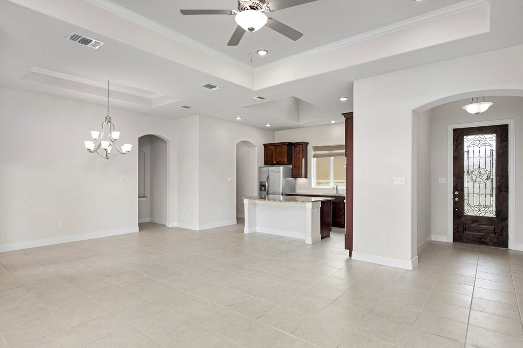 a kitchen and living room with a ceiling fan