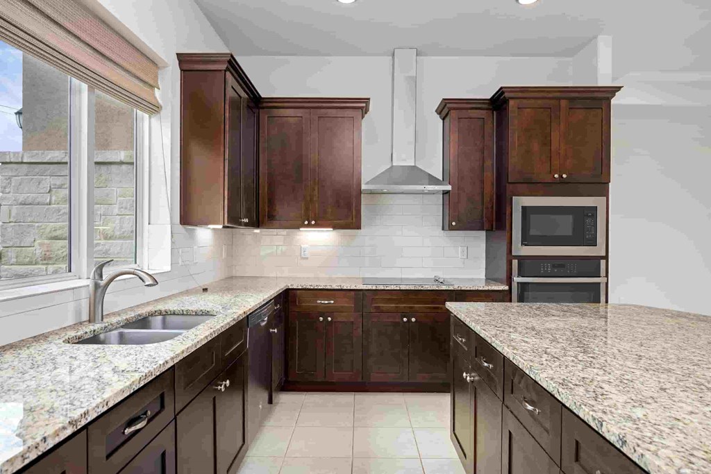 a kitchen with marble counter tops and wooden cabinets