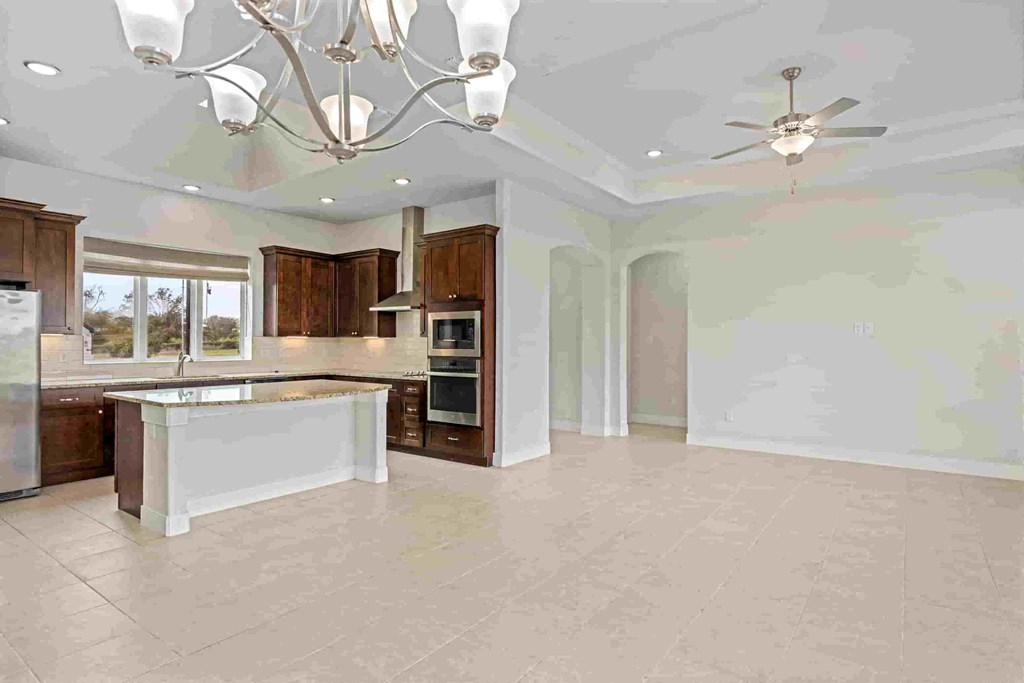 a large kitchen with a large island and a chandelier