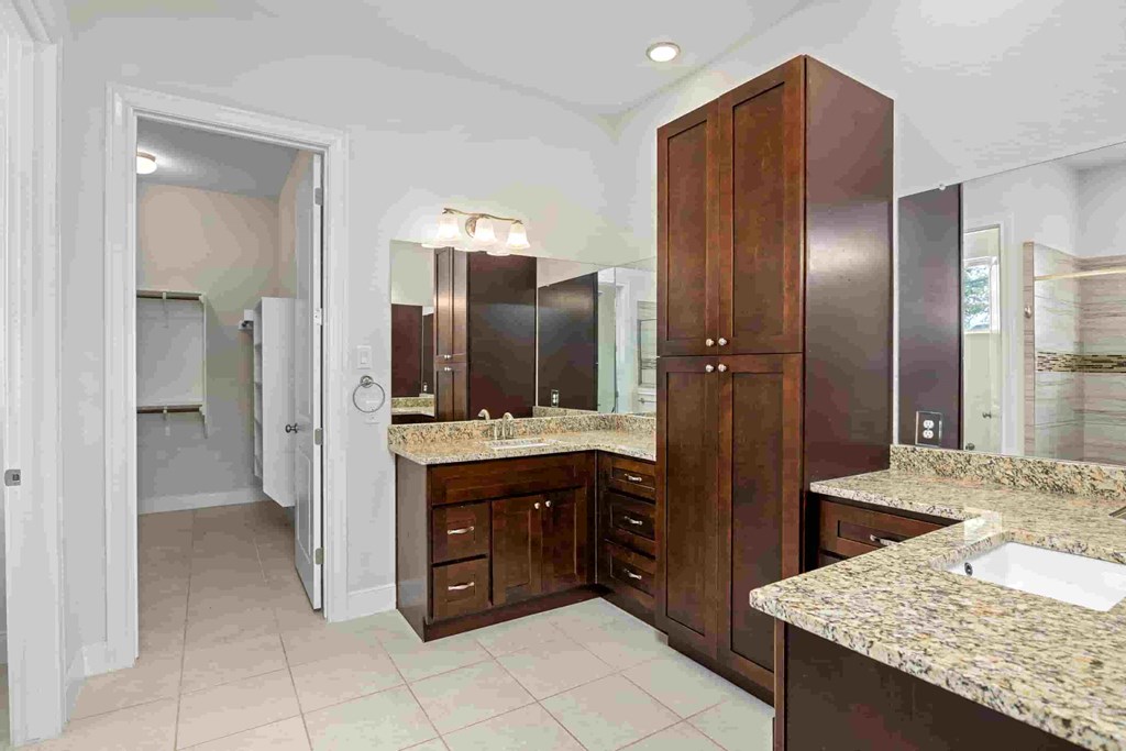 a large bathroom with granite counter tops and wooden cabinets